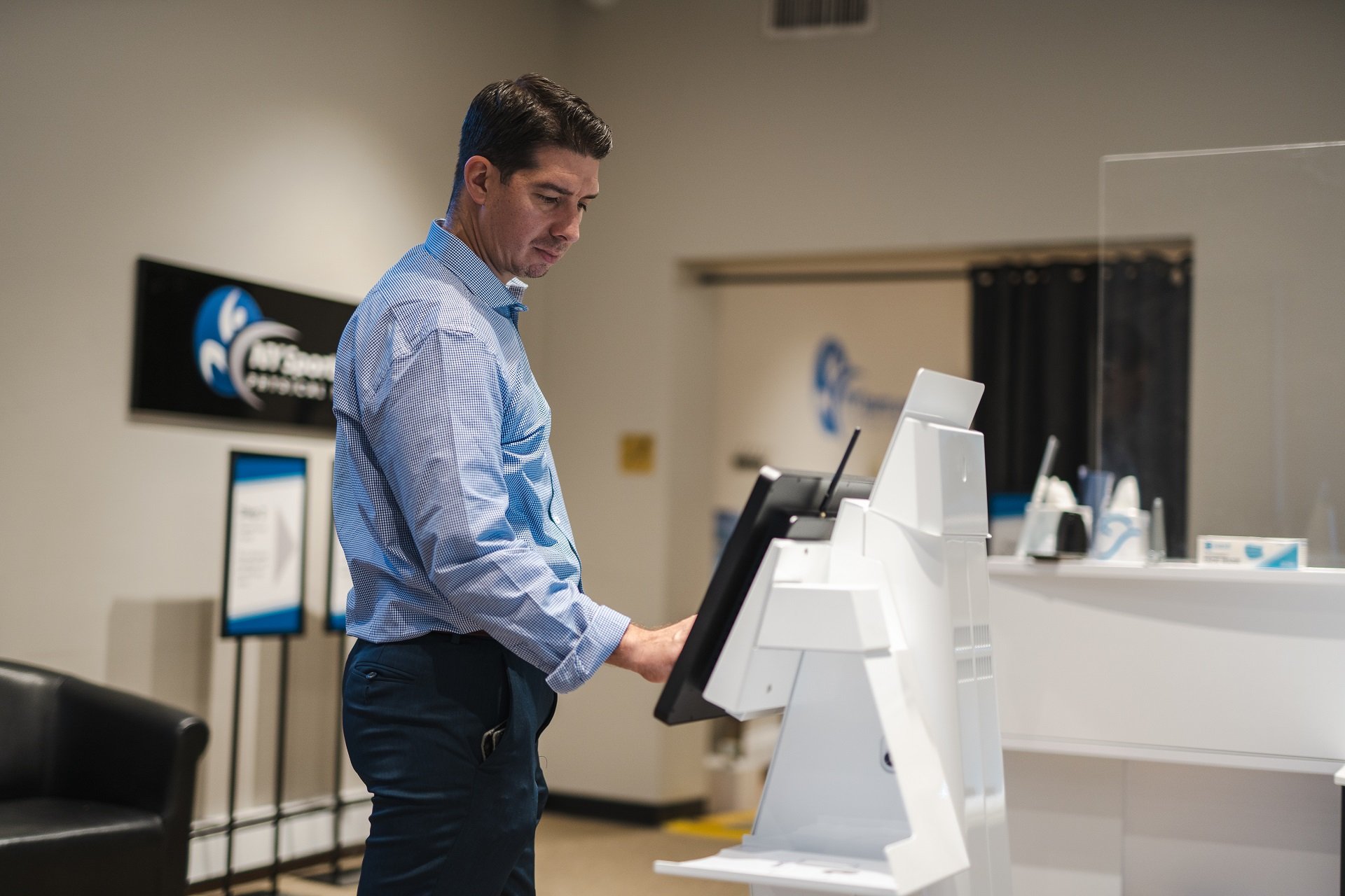 Man using the kiosk in one of the types of outpatient clinics